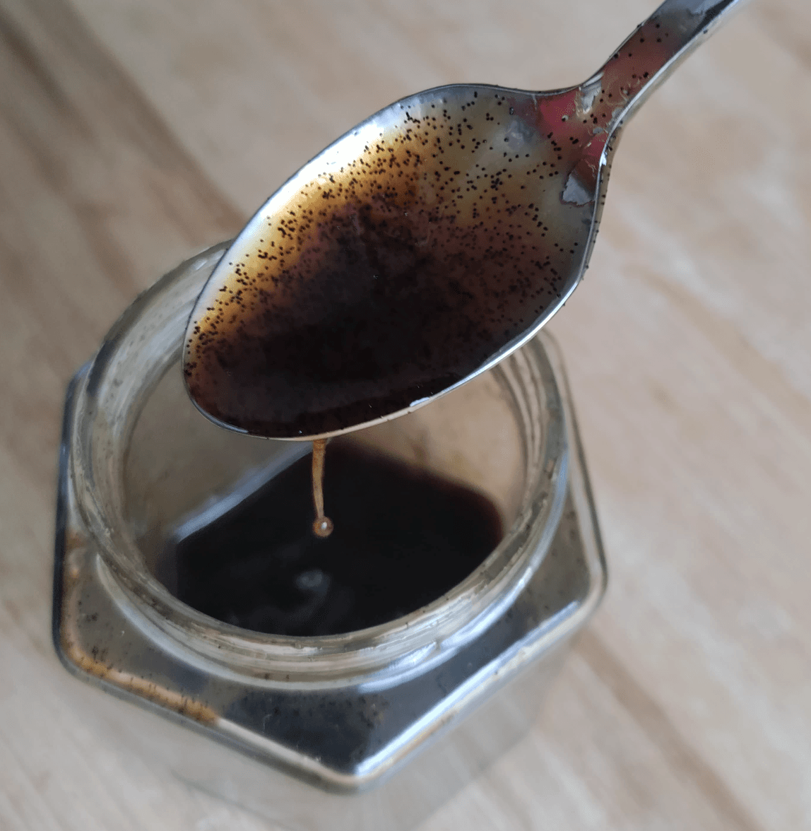 Lepel Vanora Vanille Caviar Paste met zichtbare vanillezaadjes, boven een open pot.